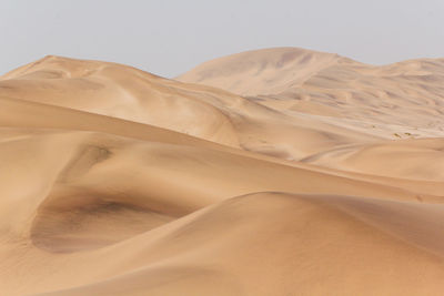 Sand dunes in desert against sky