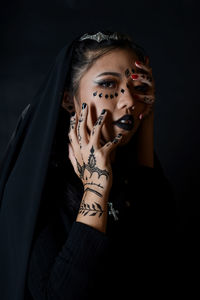 Portrait of a young woman over black background