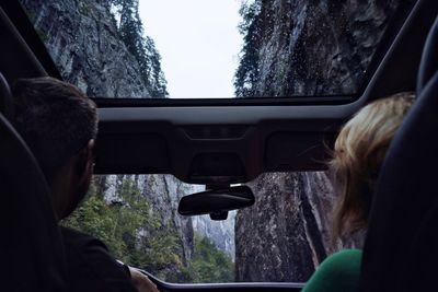 Rear view of people traveling in car amidst mountains