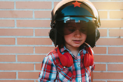 Boy wearing helmet against wall