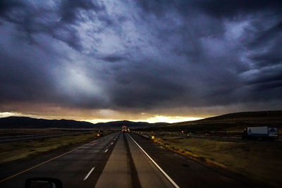 View of country road against cloudy sky