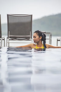Beautiful woman enjoying a relaxing time in the pool of luxury resort