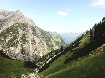 Scenic view of valley and mountains against sky