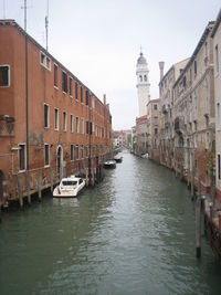 Canal amidst buildings against sky