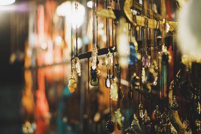 Close-up of decorations hanging for sale at market during night