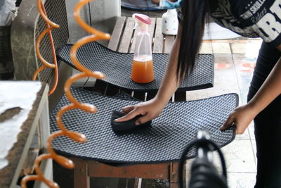 High angle view of woman cleaning equipment on bench