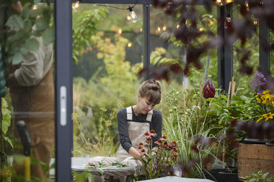 Woman sitting in greenhouse