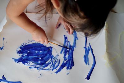 Girl painting on paper at home