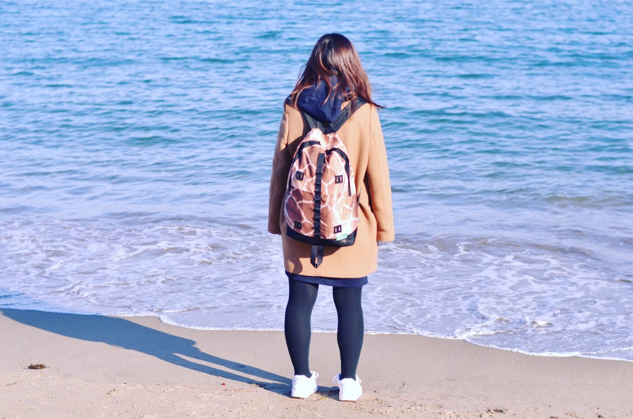 beach, sea, water, lifestyles, leisure activity, standing, sand, shore, full length, young adult, vacations, casual clothing, person, rear view, young women, sunlight, outdoors, front view