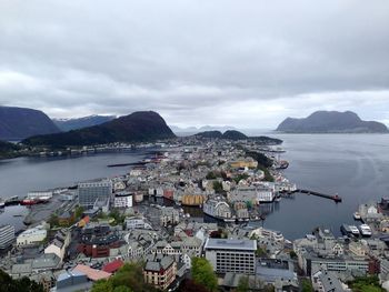 Cityscape by sea against sky