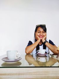 Portrait of young woman sitting on table