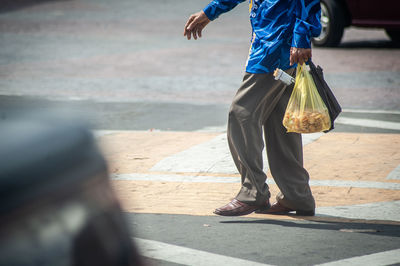 Low section of man walking on sidewalk