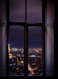 Illuminated buildings seen through window at night