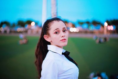 Portrait of young woman against sky