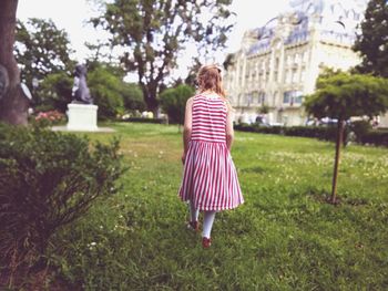 Rear view of girl walking on grass