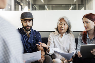 Business people discussing documents in meeting room