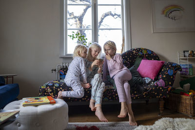 Sisters sitting on sofa barefoot