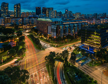 High angle view of illuminated street amidst buildings at night