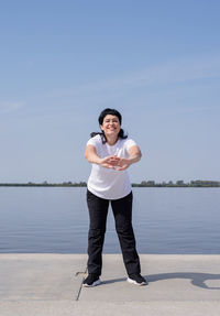 Portrait of man standing in lake against sky