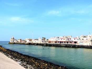 View of sea and buildings against sky