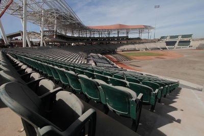 Empty chairs in row against sky