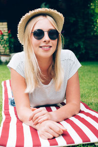 Beautiful young woman wearing hat sitting outdoors