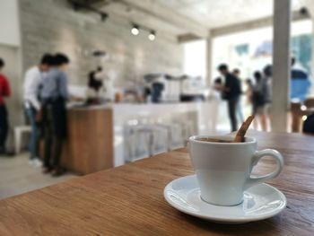 Coffee on wood table, cafe background.