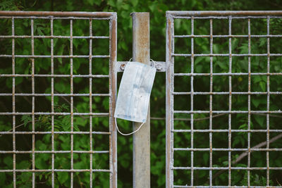 Close-up of wooden post hanging on fence