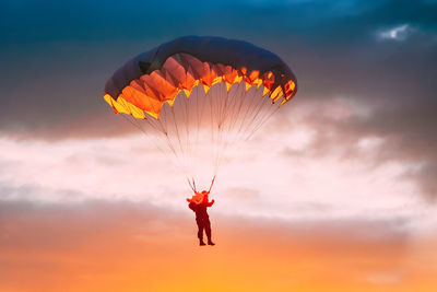 Low angle view of red balloons against sky during sunset