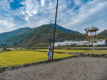 Man standing on field against sky