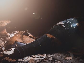 Close-up of abandoned bottle against sky at night