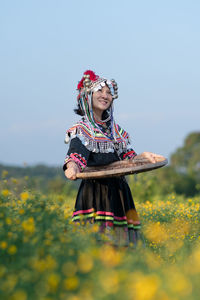 Low angle view of woman with umbrella on field against sky