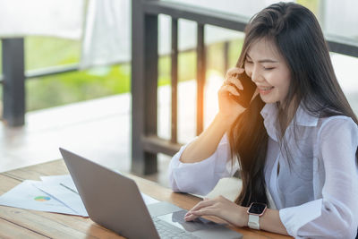 Young woman using laptop at table