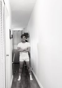 Portrait of young man standing at entrance of building