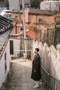 Man standing against building in city