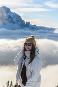 Portrait of woman in front of amazing alpine landscape with snow capped mountains