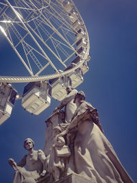 Low angle view of ferris wheel against blue sky