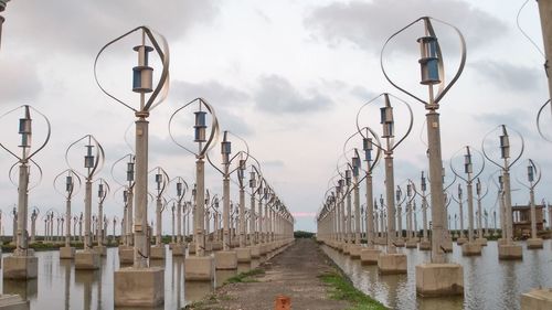 Street lights on footpath against sky