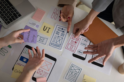 Cropped hands of business colleagues working on table