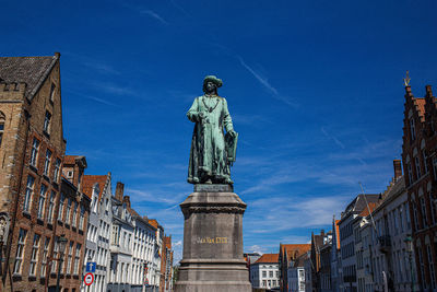 Low angle view of statue against blue sky