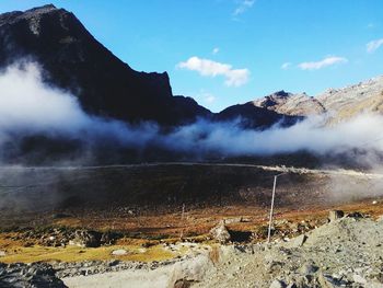 Smoke emitting from mountain against sky