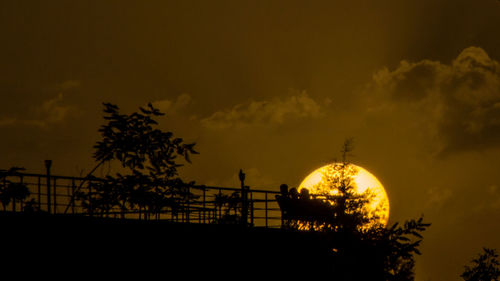 Silhouette trees against sky at sunset