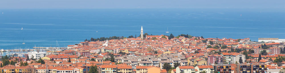 High angle view of townscape by sea against sky