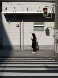 Woman walking on footpath in city