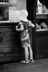 Rear view of girl standing by store