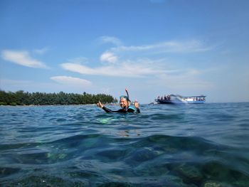 Man surfing in sea against sky