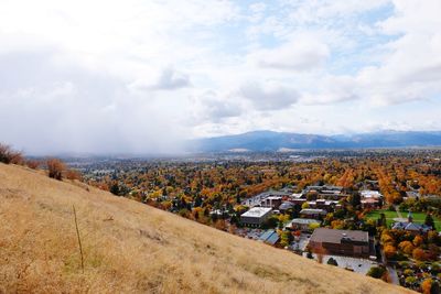 High angle view of field by buildings against sky