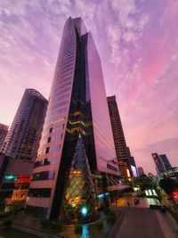 Low angle view of illuminated buildings against sky during sunset