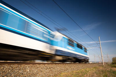 Train on railroad tracks against blue sky