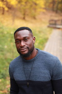 Portrait of smiling man standing against trees